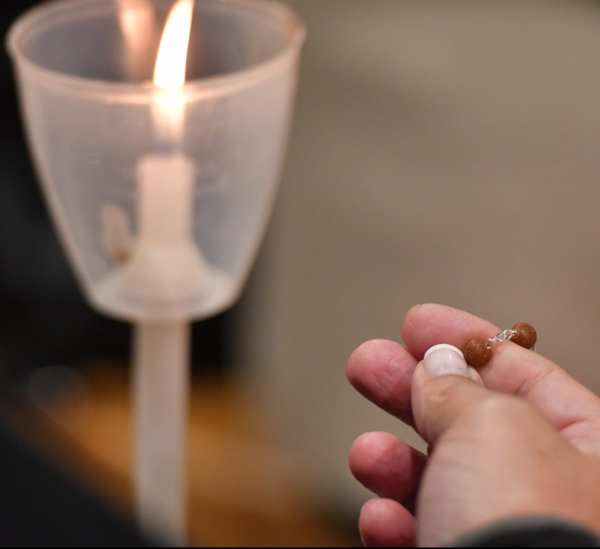 Com o terço e uma vela